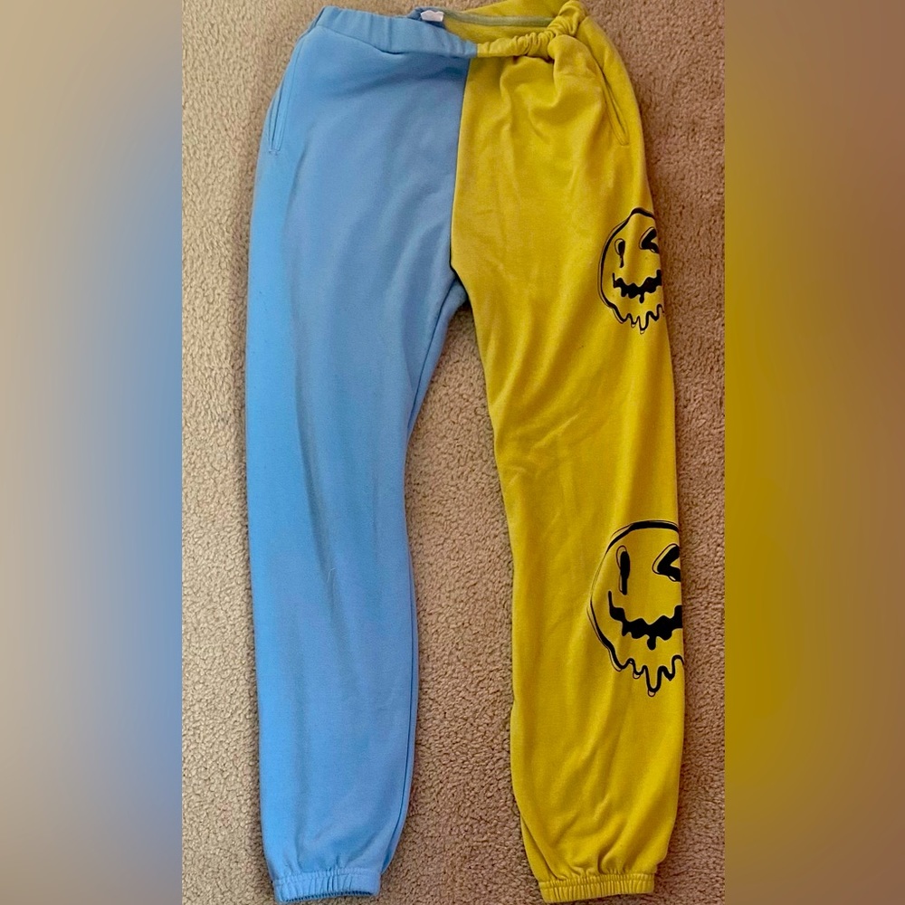 Is a multicolored sweatpants with smiley faces on the right pant leg.